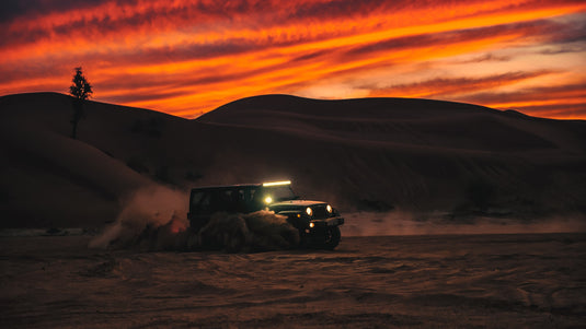 Truck off road with desert hill beyond. Photo by Issac Mitchell