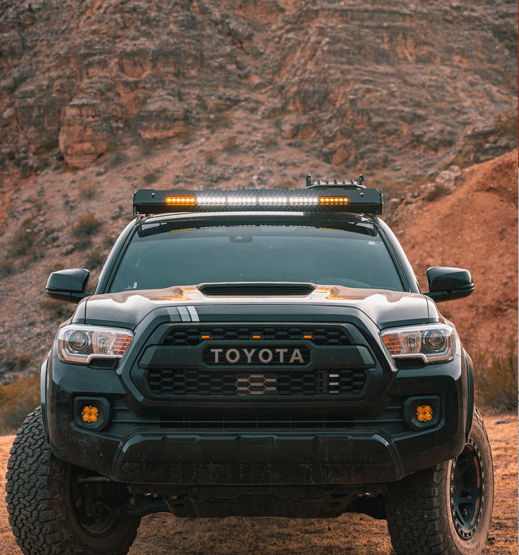 Truck off road with desert hill beyond, photo by Issac Mitchell.