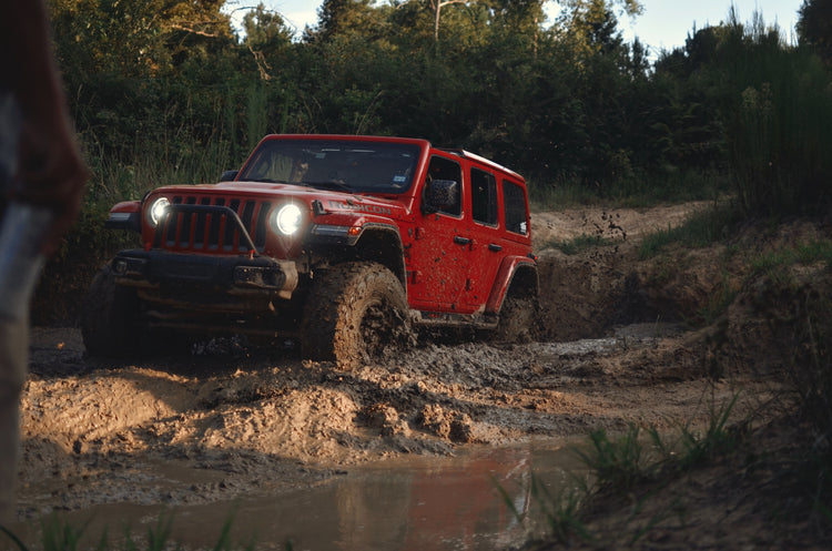 Red Jeep stuck in deep mud. Photo by Jeff James