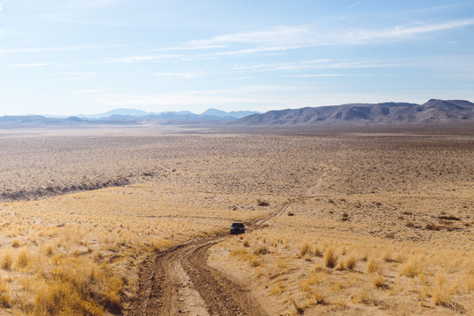 Jeep approaching on dirt road in desert valley. Photo by Wesley Tingey.