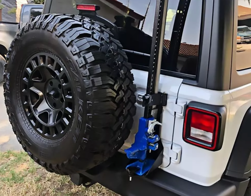 Load image into Gallery viewer, Rear of white jeep with bracket installed and jack unit attached
