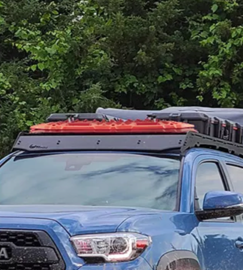 Recovery boards and storage boxes on roof rack of blue truck
